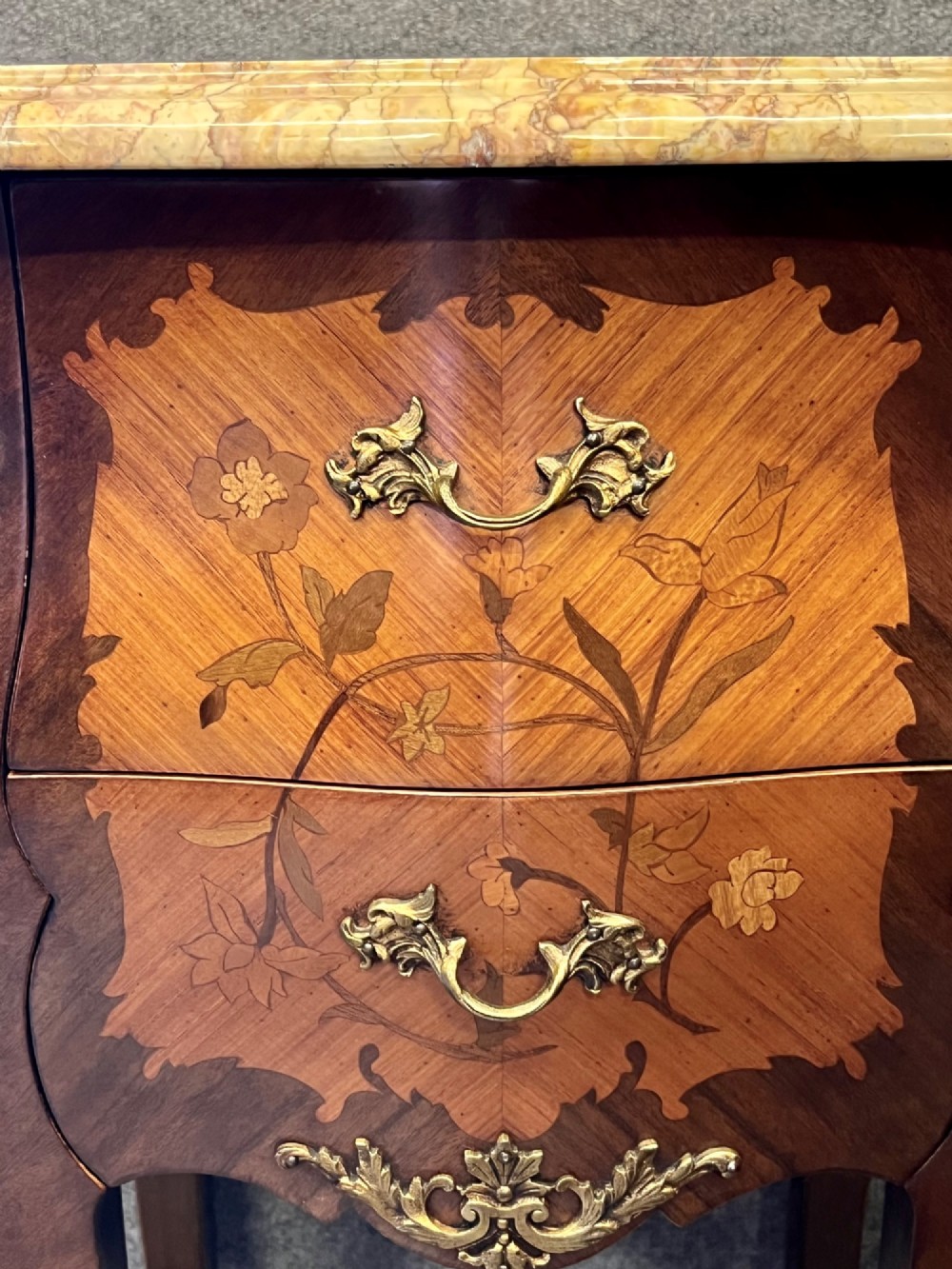 A pair of French Louis XV style bedside tables featuring marble tops, two floral marquetry drawers, gilt-bronze mounts, and slender cabriole legs. View VII