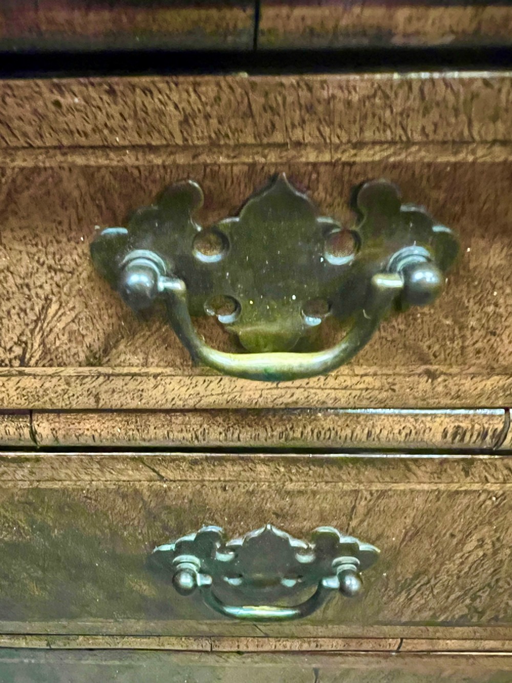 A small 18th-century style walnut chest of drawers featuring figured wood grain, brass drop handles, and bracket feet. View VI