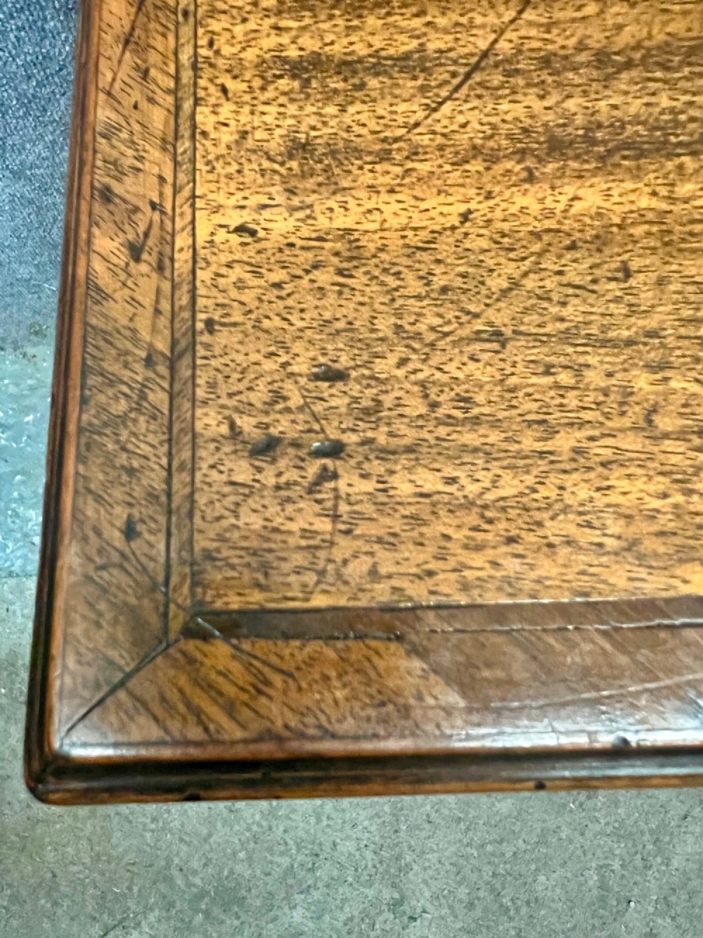 A small 18th-century style walnut chest of drawers featuring figured wood grain, brass drop handles, and bracket feet. View IX
