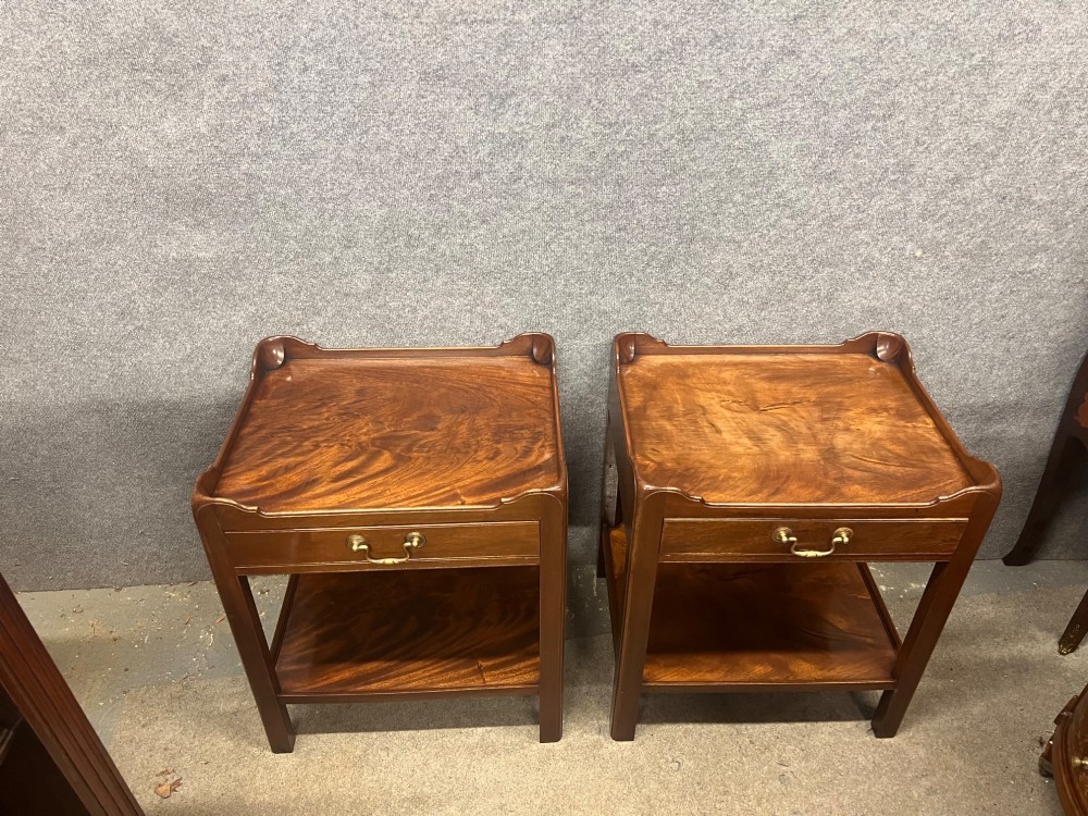 A matching pair of Georgian style mahogany bedside tables featuring flame mahogany tops with shaped gallery edges, single drawers, and open lower shelves. View II