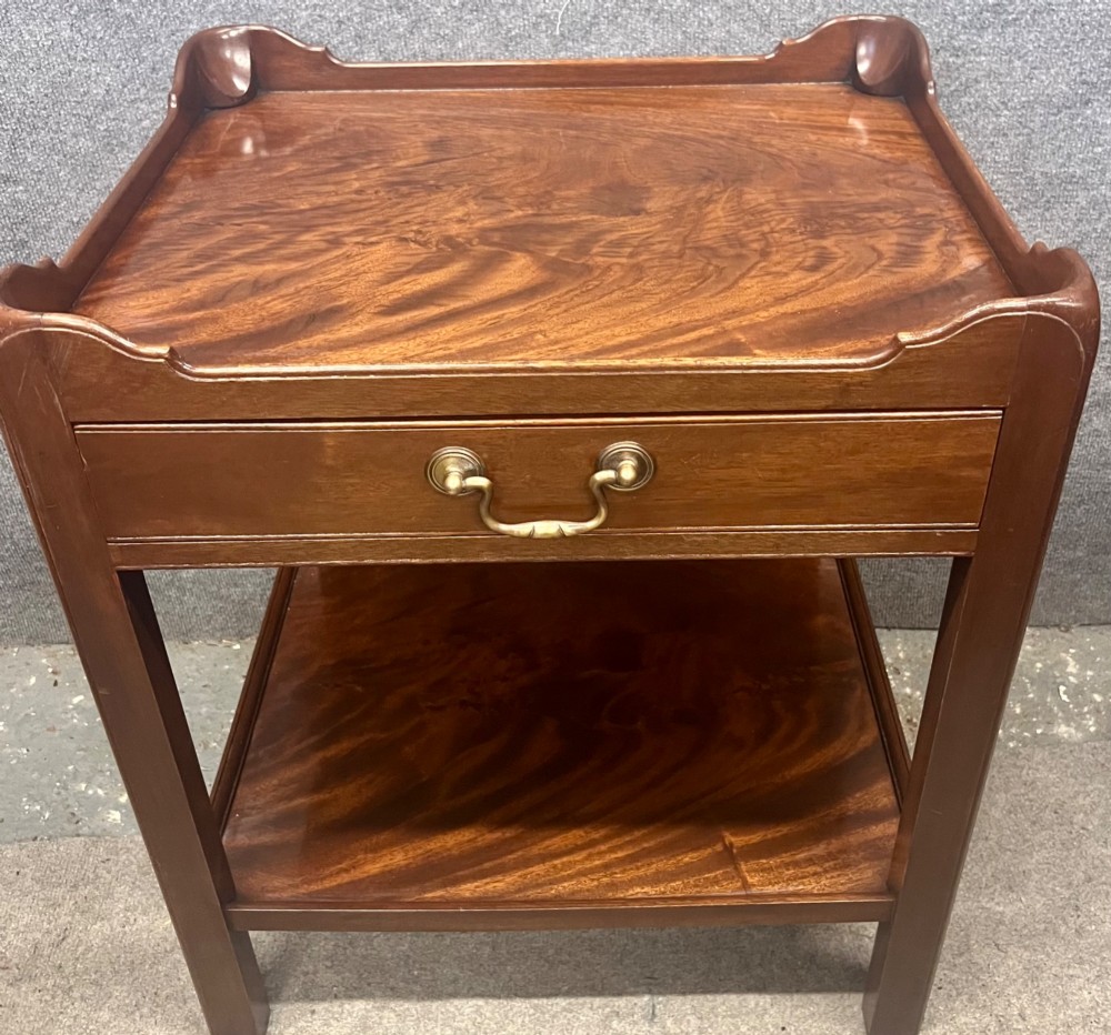 A matching pair of Georgian style mahogany bedside tables featuring flame mahogany tops with shaped gallery edges, single drawers, and open lower shelves. View VI