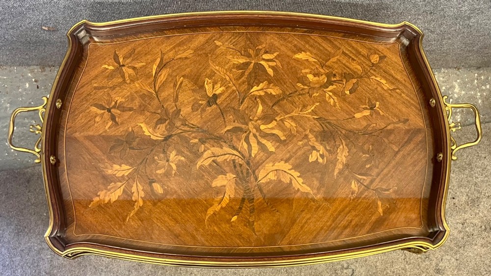 A French Louis XV style coffee table featuring a floral marquetry tray top with brass gallery rim, handles, and gilt metal mounts on curved cabriole legs. View II