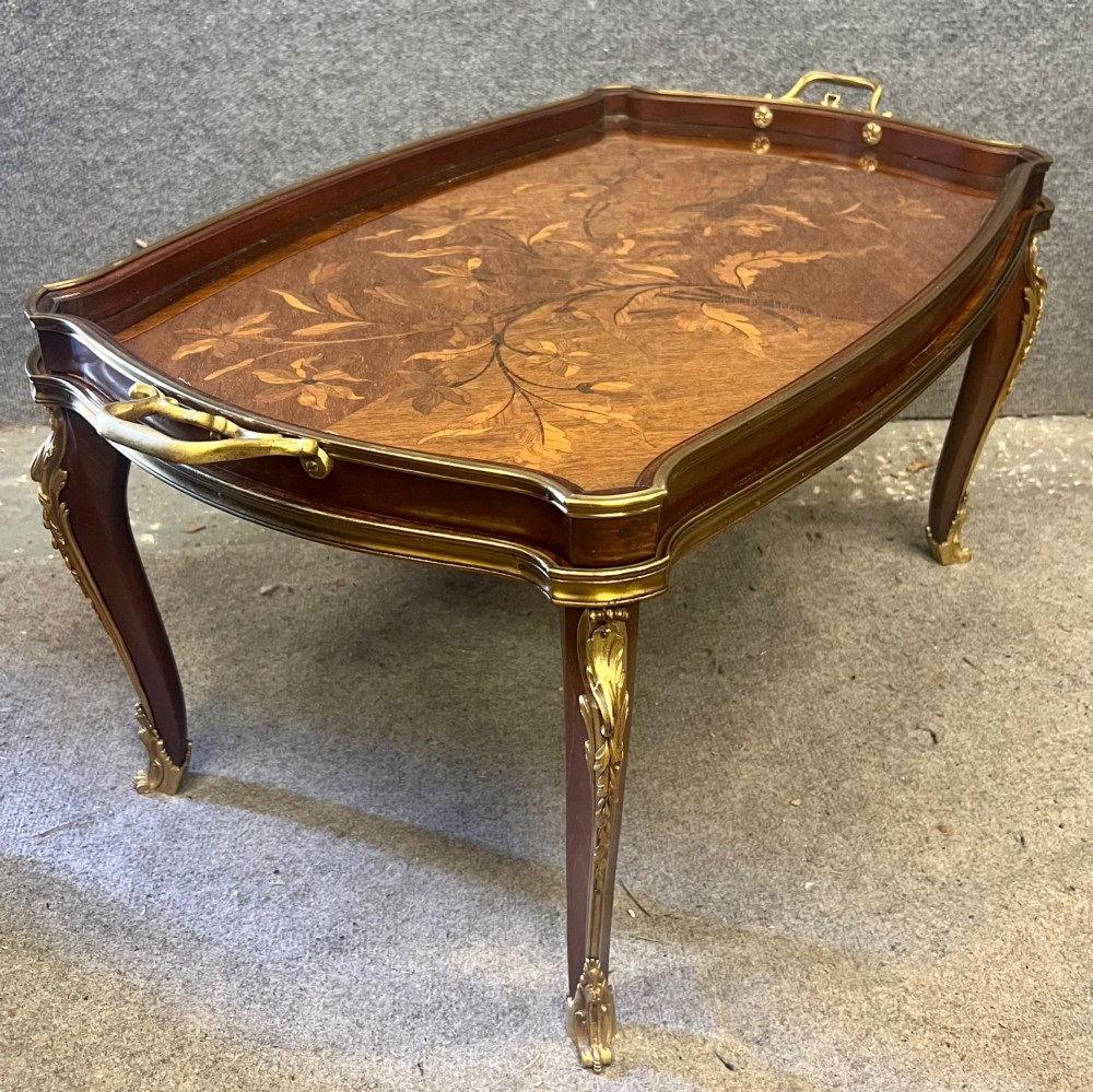 A French Louis XV style coffee table featuring a floral marquetry tray top with brass gallery rim, handles, and gilt metal mounts on curved cabriole legs. View V