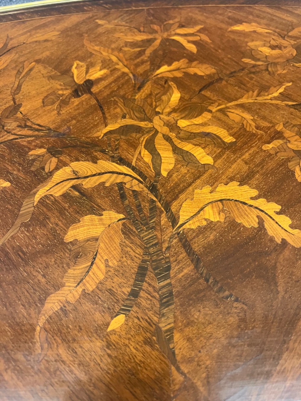 A French Louis XV style coffee table featuring a floral marquetry tray top with brass gallery rim, handles, and gilt metal mounts on curved cabriole legs. View VI
