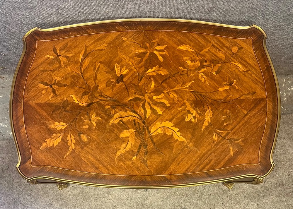 A French Louis XV style coffee table featuring a floral marquetry tray top with brass gallery rim, handles, and gilt metal mounts on curved cabriole legs. View VII