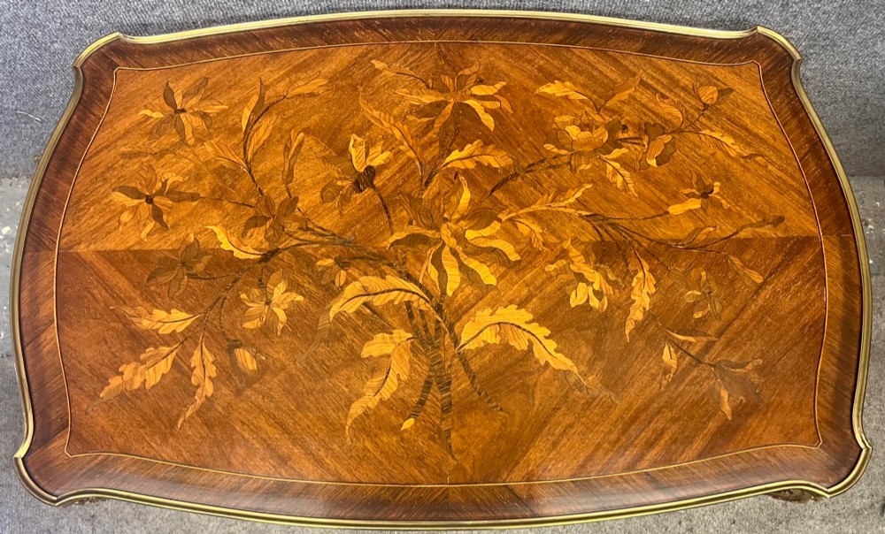 A French Louis XV style coffee table featuring a floral marquetry tray top with brass gallery rim, handles, and gilt metal mounts on curved cabriole legs. View IX