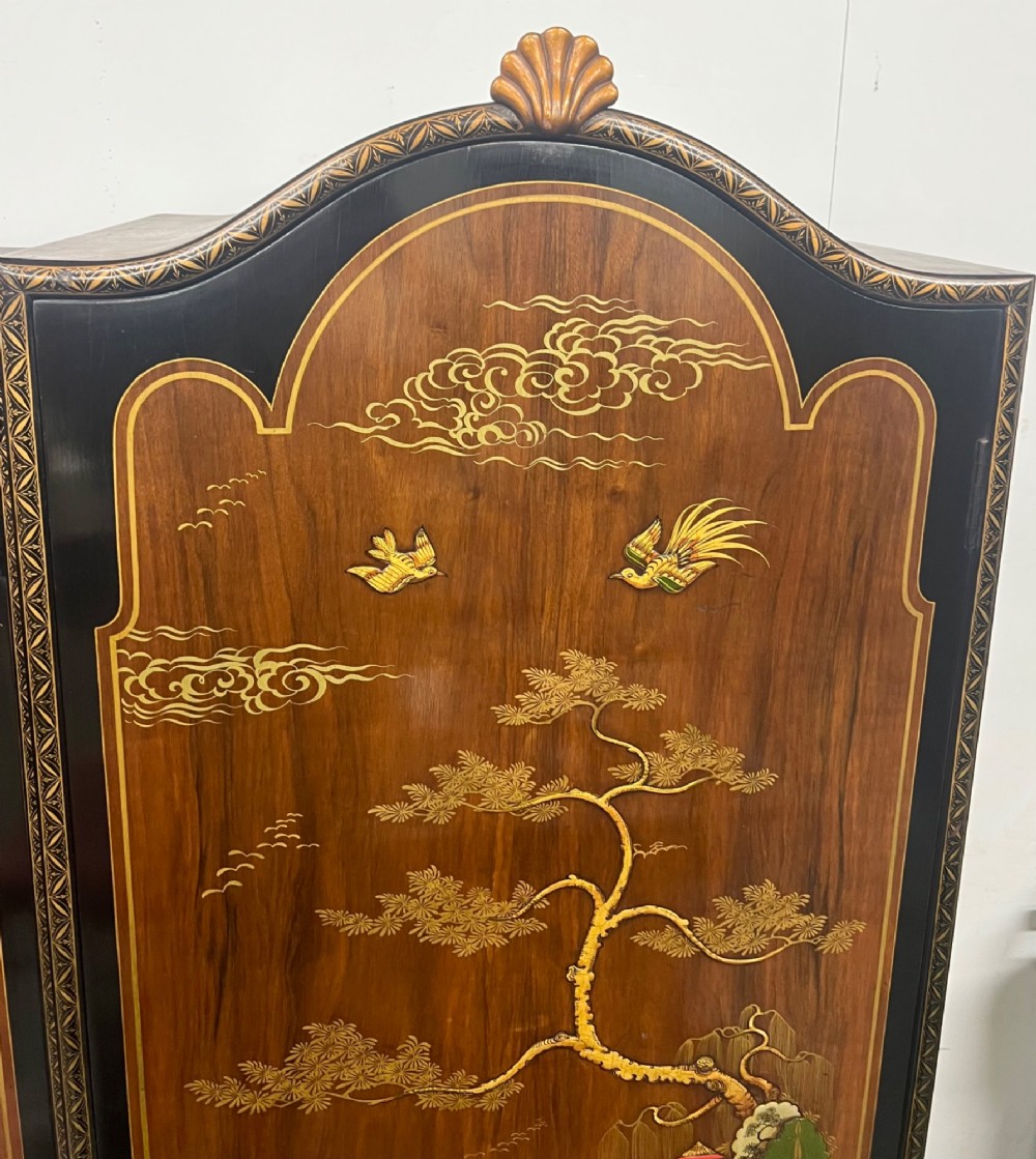 A triple-door Chinoiserie wardrobe featuring intricate gilded Asian landscape scenes, shell-carved crests, and dark polished wood frames. View VII