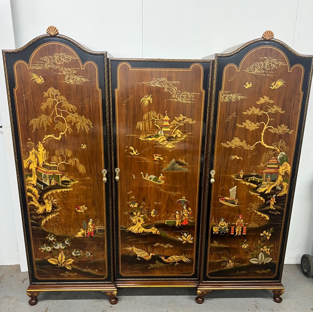 A triple-door Chinoiserie wardrobe featuring intricate gilded Asian landscape scenes, shell-carved crests, and dark polished wood frames. View XI