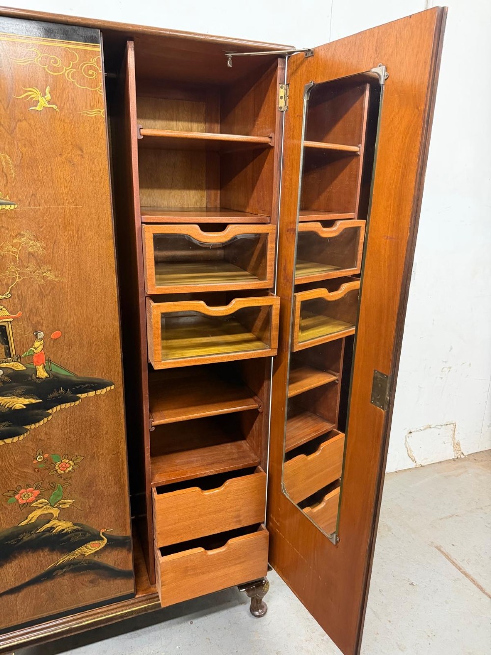 A two-door wooden compactum wardrobe decorated with hand-painted Chinoiserie scenes, pagodas, and figures set within dark lacquered borders. View II