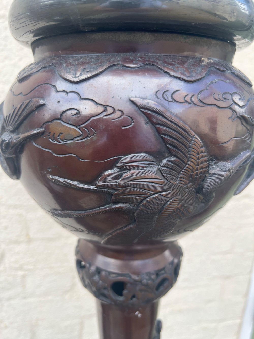 A tall Japanese Meiji period dark bronze floor lamp featuring high-relief relief castings of birds and floral branches along a baluster column. View V
