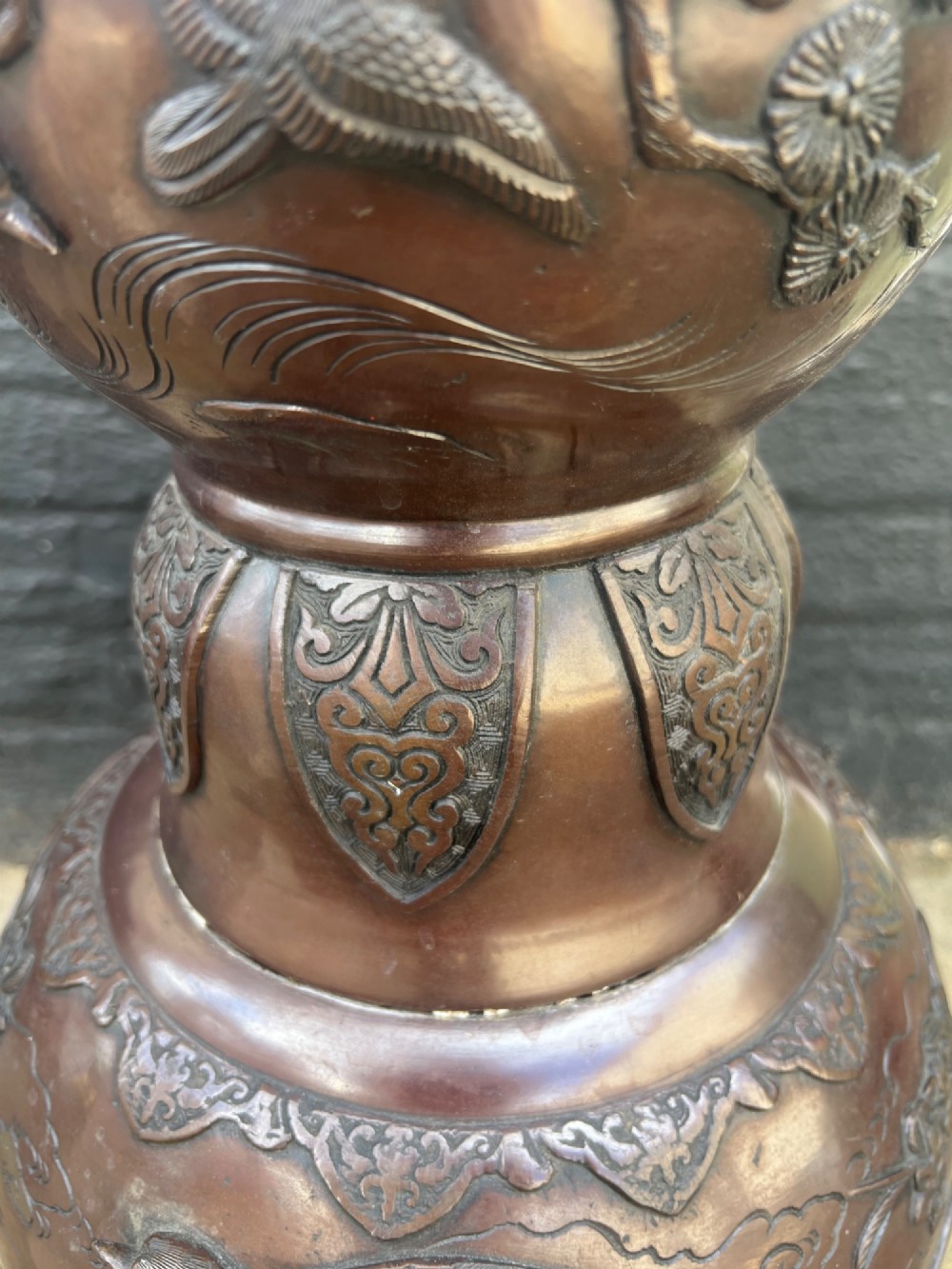A tall Japanese Meiji period dark bronze floor lamp featuring high-relief relief castings of birds and floral branches along a baluster column. View VII