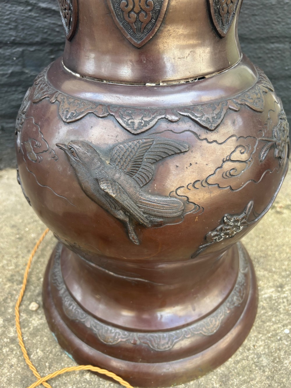 A tall Japanese Meiji period dark bronze floor lamp featuring high-relief relief castings of birds and floral branches along a baluster column. View VIII
