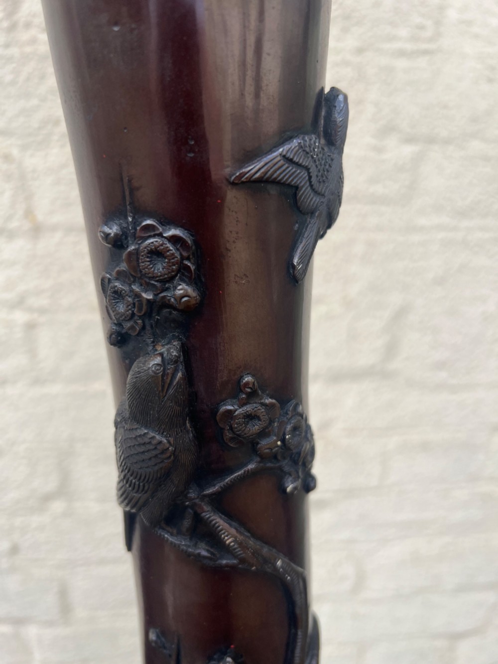 A tall Japanese Meiji period dark bronze floor lamp featuring high-relief relief castings of birds and floral branches along a baluster column. View XII