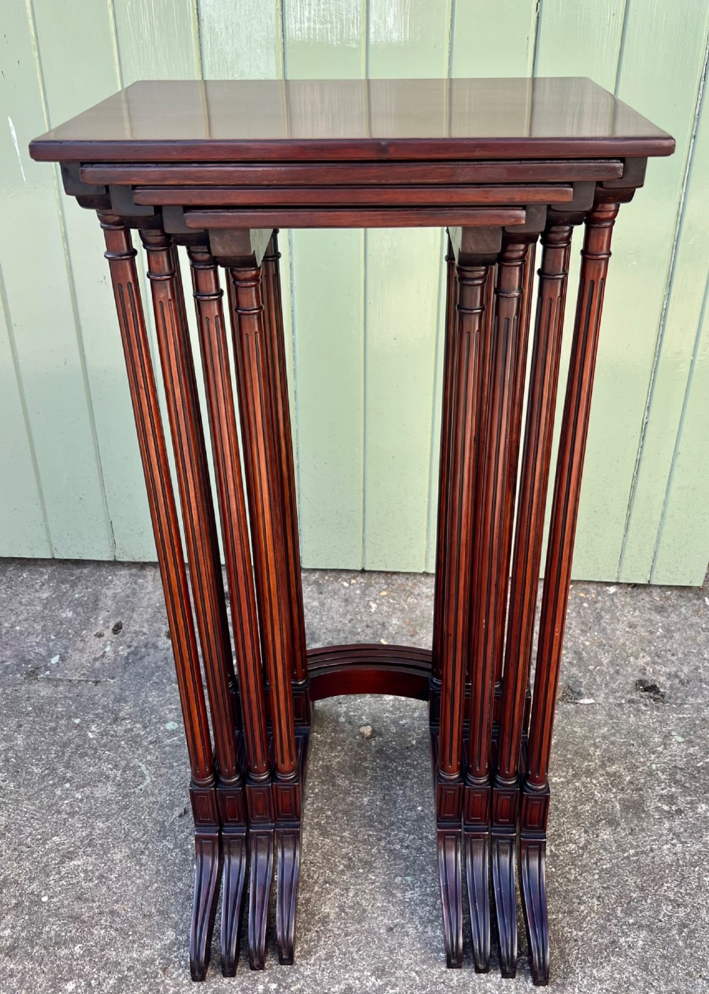 A set of four graduated Edwardian mahogany nesting tables featuring rectangular tops, slender fluted legs, and curved stretchers. View II