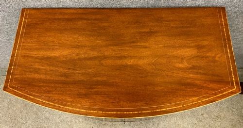 An Edwardian demi-lune mahogany cabinet featuring twin doors with oval inlaid veneer panels and short tapered legs. View III
