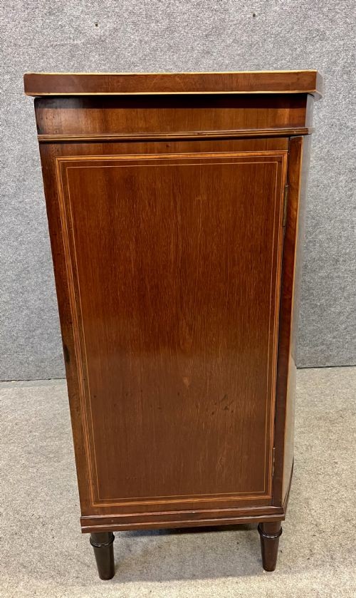 An Edwardian demi-lune mahogany cabinet featuring twin doors with oval inlaid veneer panels and short tapered legs. View VI
