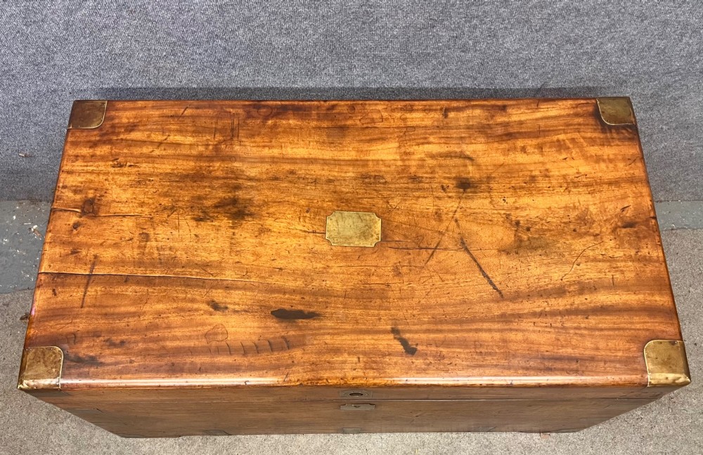 A rectangular Anglo-Indian campaign trunk crafted from warm brown wood with protective brass corner straps and metal carrying handles. View III