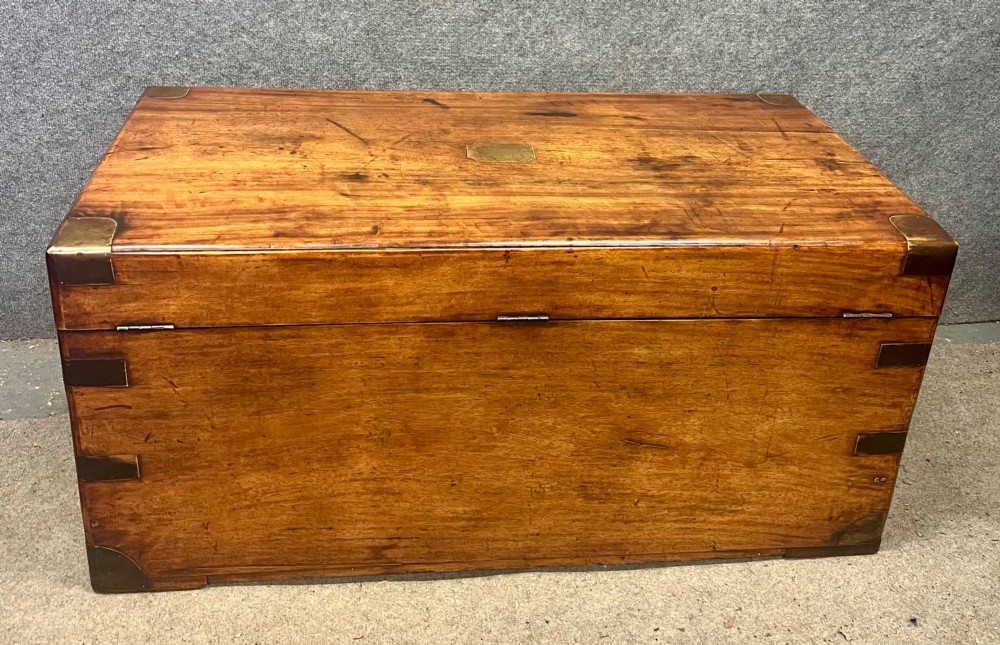 A rectangular Anglo-Indian campaign trunk crafted from warm brown wood with protective brass corner straps and metal carrying handles. View IV