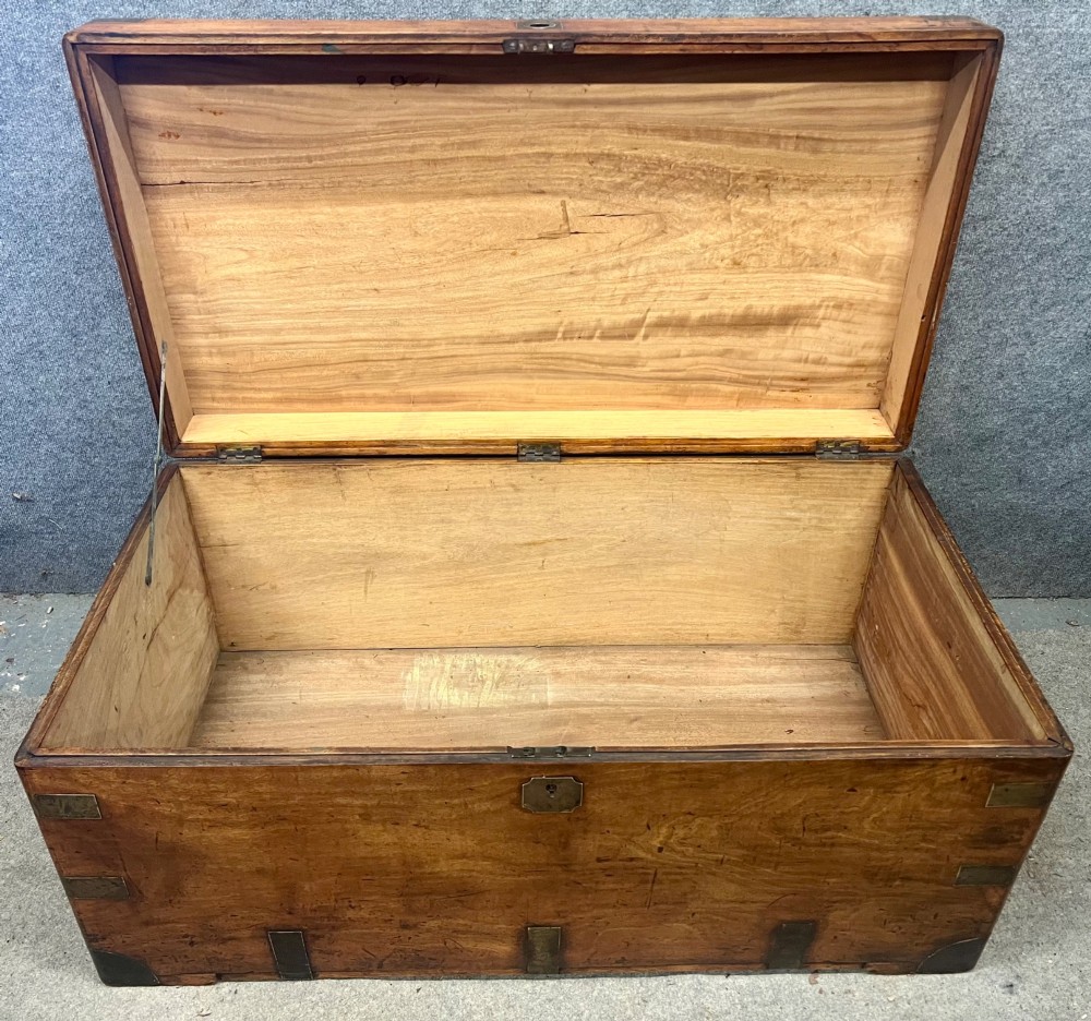 A rectangular Anglo-Indian campaign trunk crafted from warm brown wood with protective brass corner straps and metal carrying handles. View IX