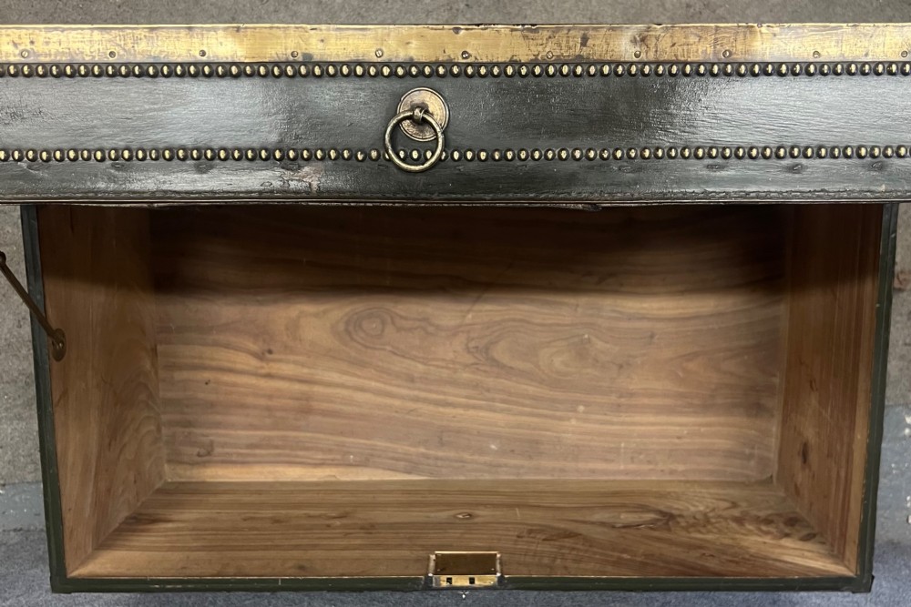 An early nineteenth-century camphor wood campaign trunk wrapped in dark olive green leather with brass stud borders, brass corner plates, side handles, and a key lock. View VI