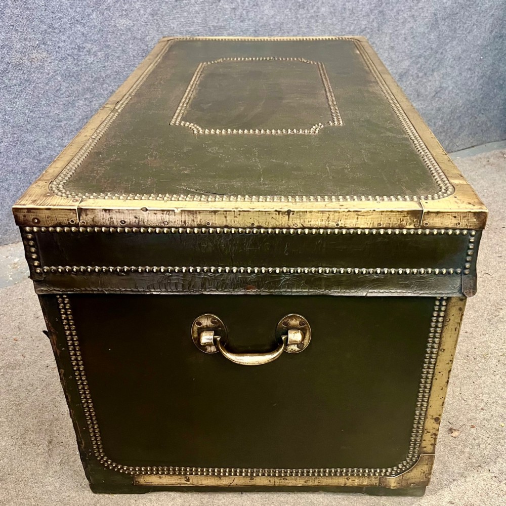 An early nineteenth-century camphor wood campaign trunk wrapped in dark olive green leather with brass stud borders, brass corner plates, side handles, and a key lock. View IX