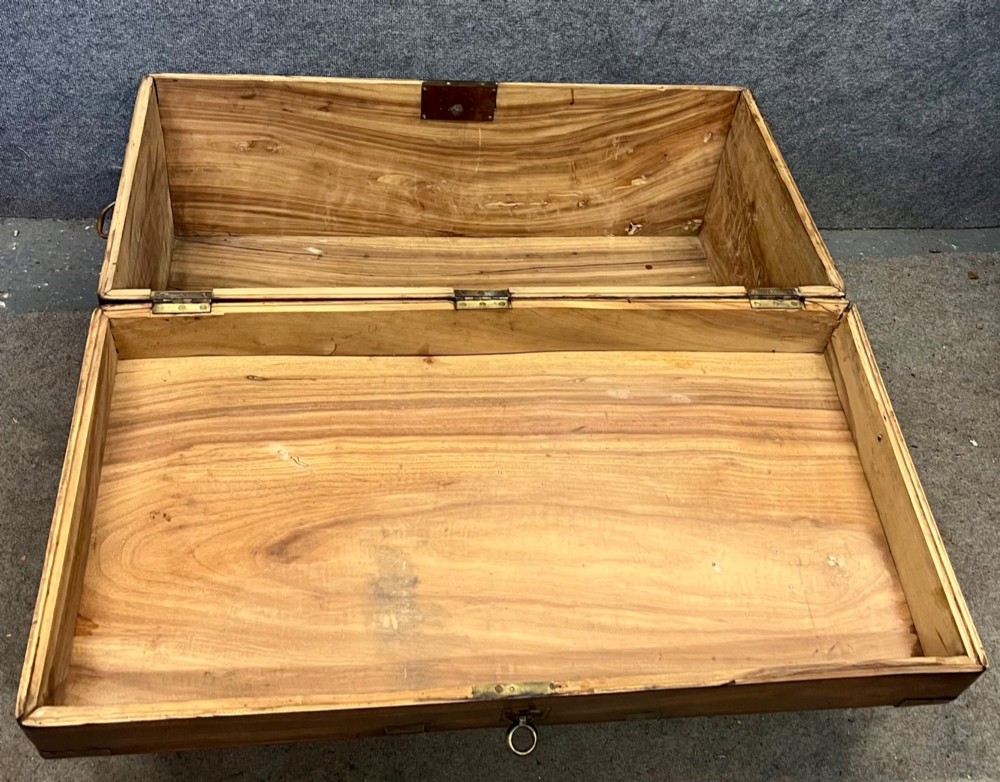 A rectangular warm brown wooden campaign trunk featuring flush brass corner brackets, metal straps, and a central brass lid plaque. View VIII