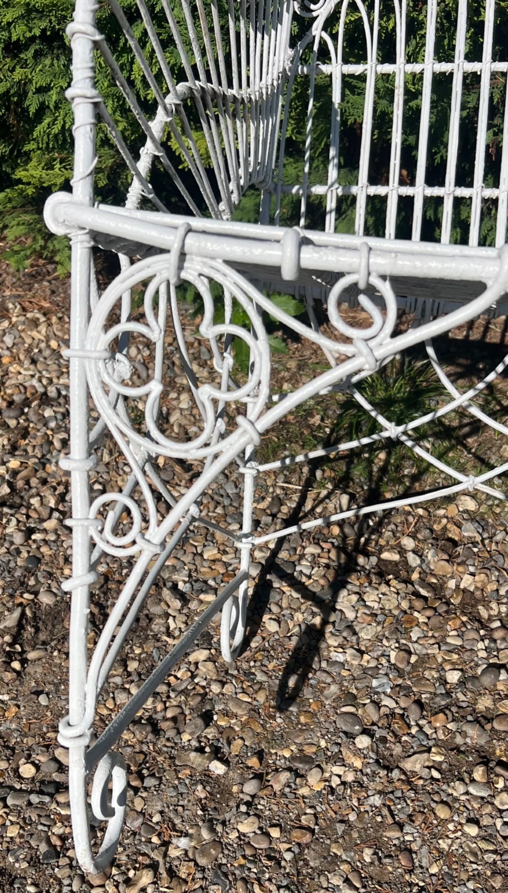 A pair of white painted iron garden chairs featuring Gothic arched backs, slatted wire seats, and scrolled feet. View III