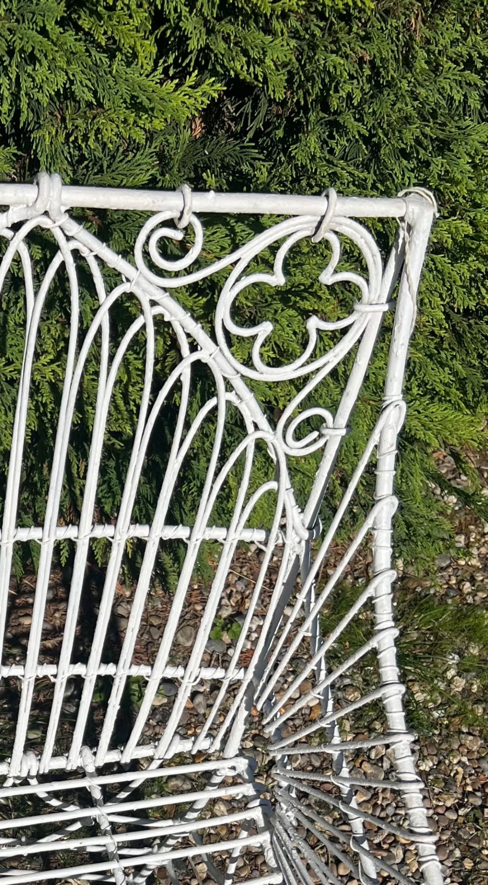A pair of white painted iron garden chairs featuring Gothic arched backs, slatted wire seats, and scrolled feet. View VII