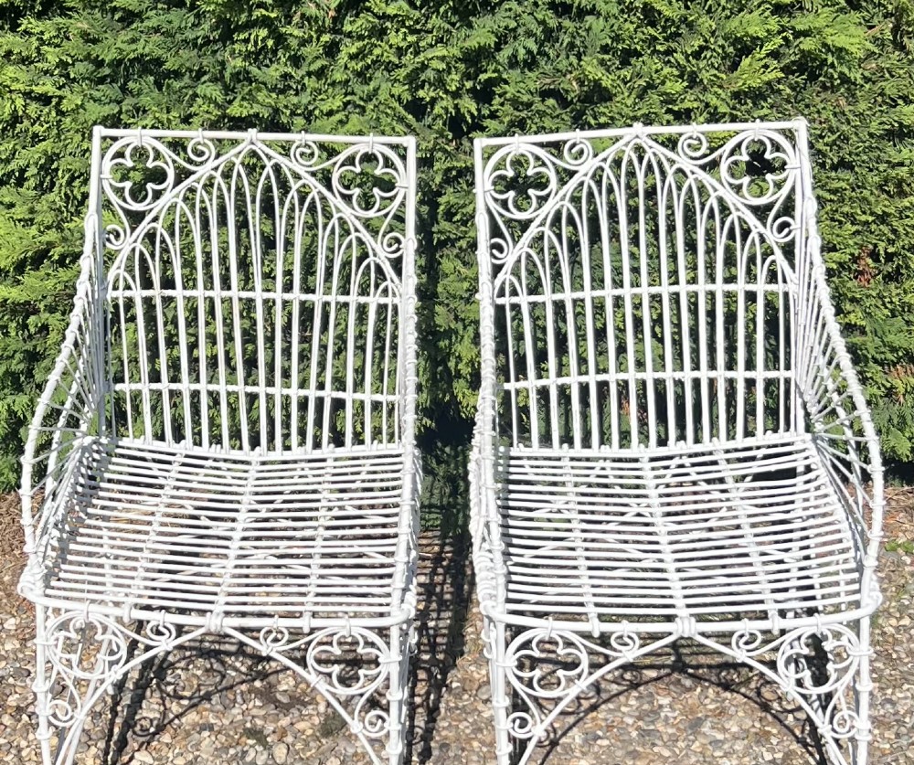 A pair of white painted iron garden chairs featuring Gothic arched backs, slatted wire seats, and scrolled feet. View VIII