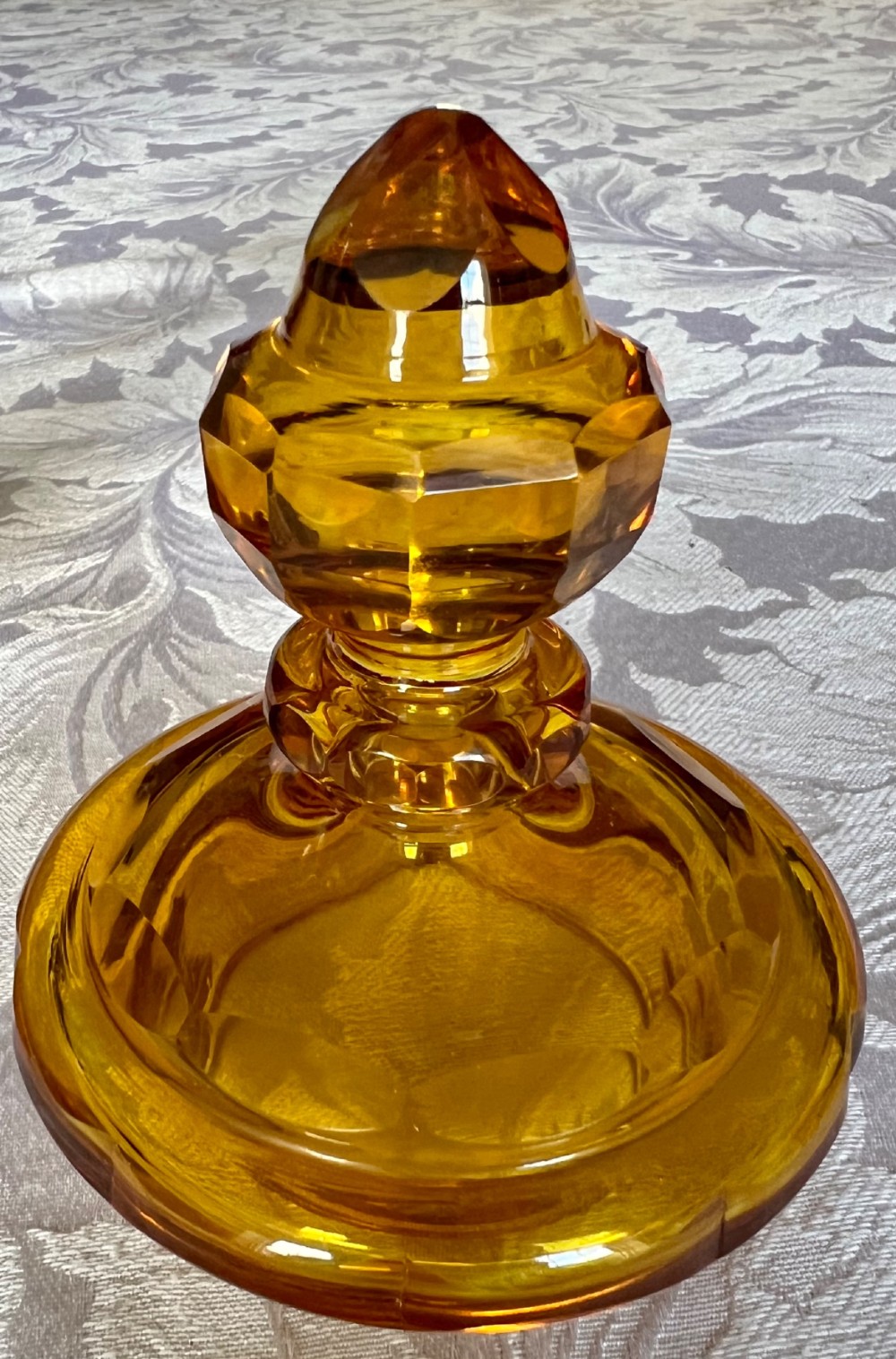 An amber glass lidded pokal vase featuring wheel-engraved woodland imagery with a stag, a faceted stem, and a stepped lid. View X