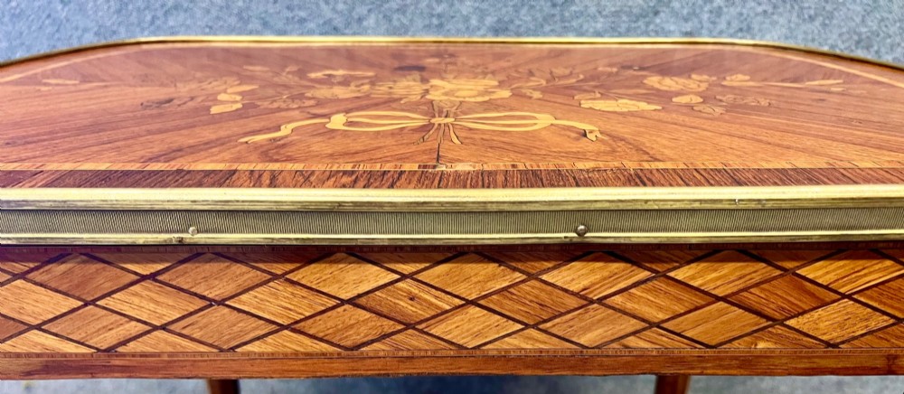 A French style low coffee table featuring floral marquetry inlay on top, diamond parquetry sides, cabriole legs, and brass corner mounts. View IV