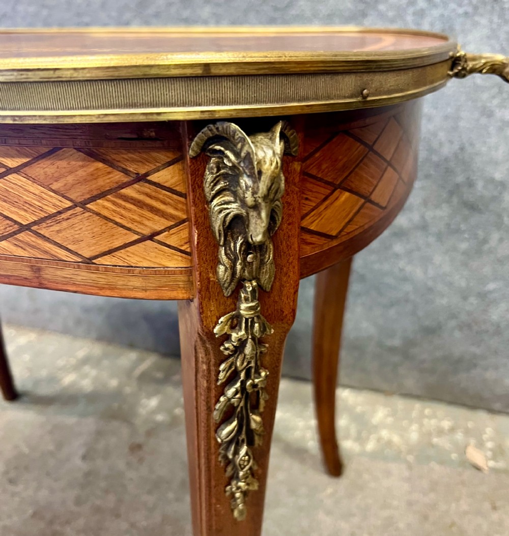 A French style low coffee table featuring floral marquetry inlay on top, diamond parquetry sides, cabriole legs, and brass corner mounts. View V