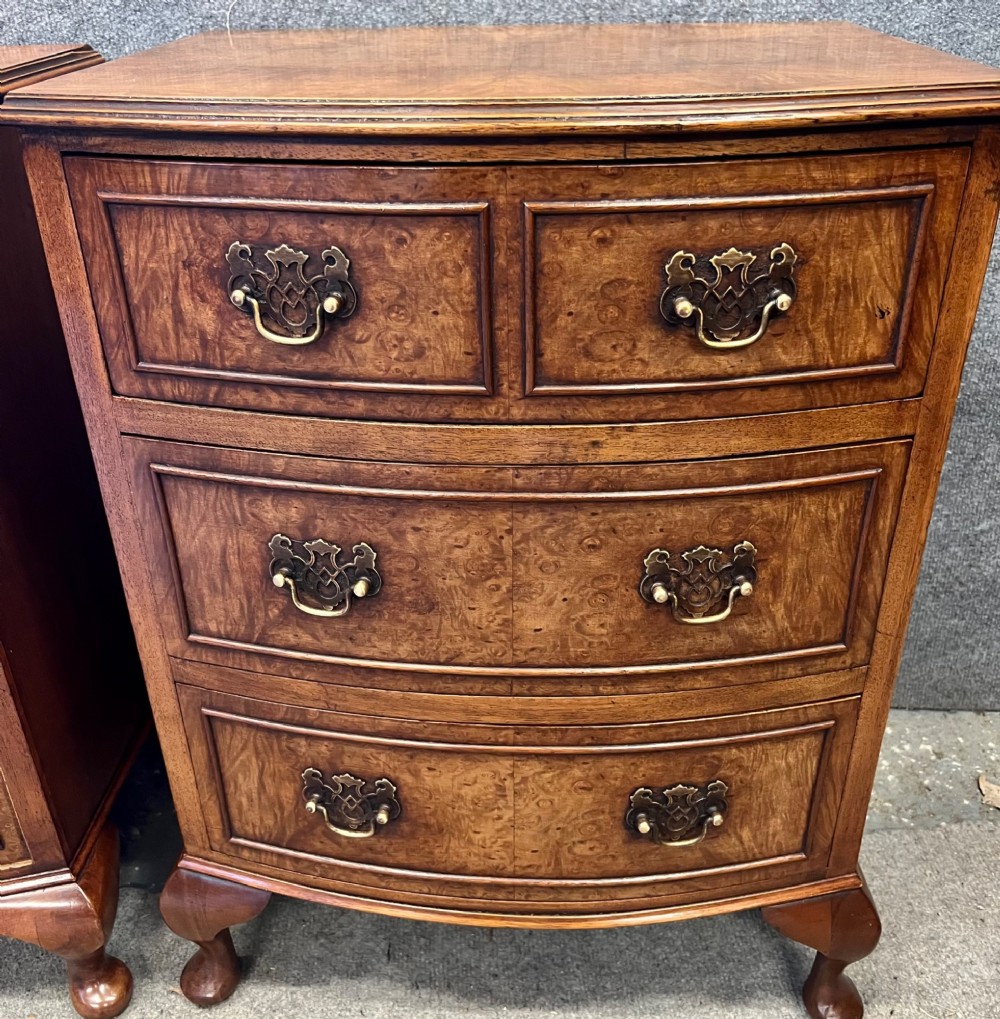 A matching pair of burr walnut bow-fronted bedside chests featuring four drawers with brass handles and cabriole legs. View IV