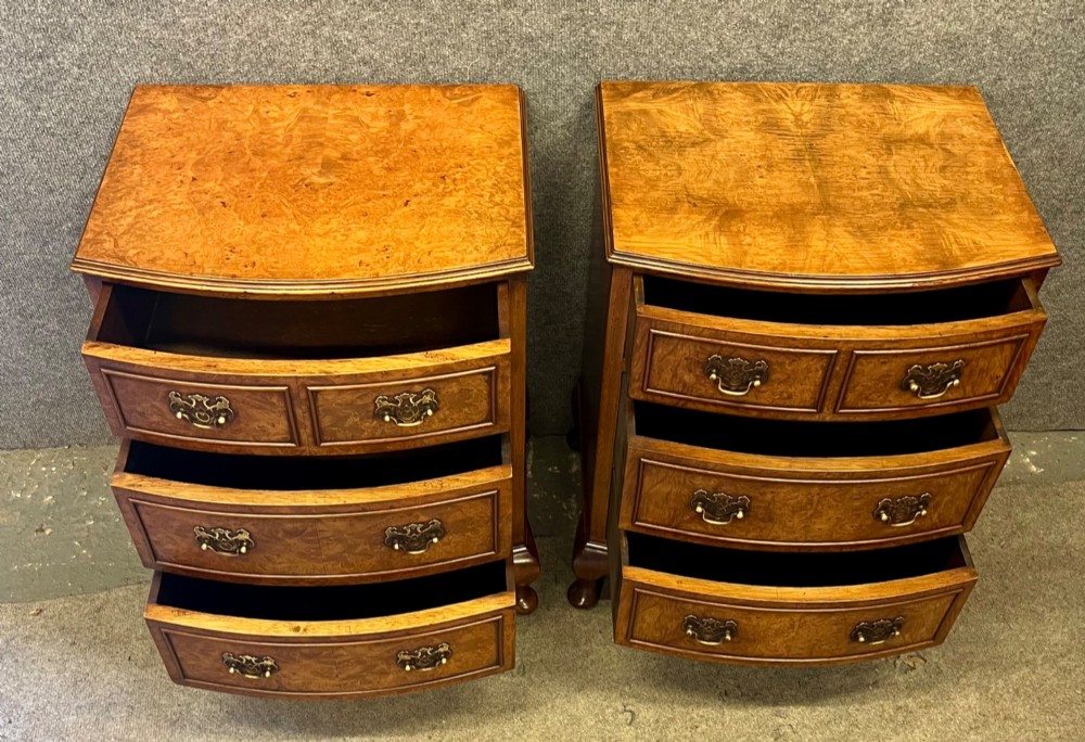 A matching pair of burr walnut bow-fronted bedside chests featuring four drawers with brass handles and cabriole legs. View VI