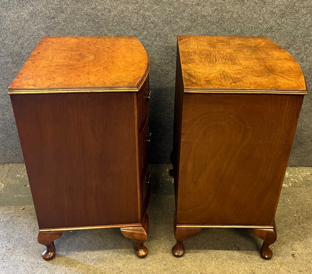 A matching pair of burr walnut bow-fronted bedside chests featuring four drawers with brass handles and cabriole legs. View VII