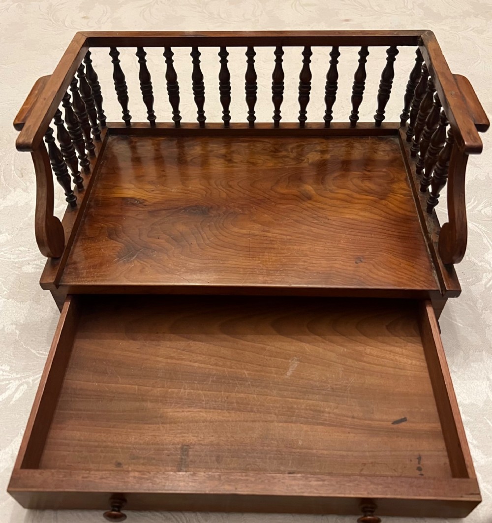 An antique yew wood desktop book trough featuring turned spindle gallery railings on three sides and a smooth timber base. View III