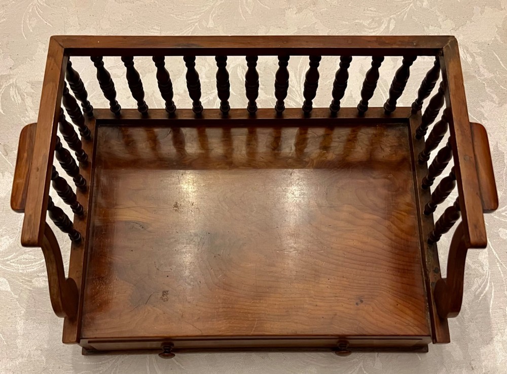 An antique yew wood desktop book trough featuring turned spindle gallery railings on three sides and a smooth timber base. View VII