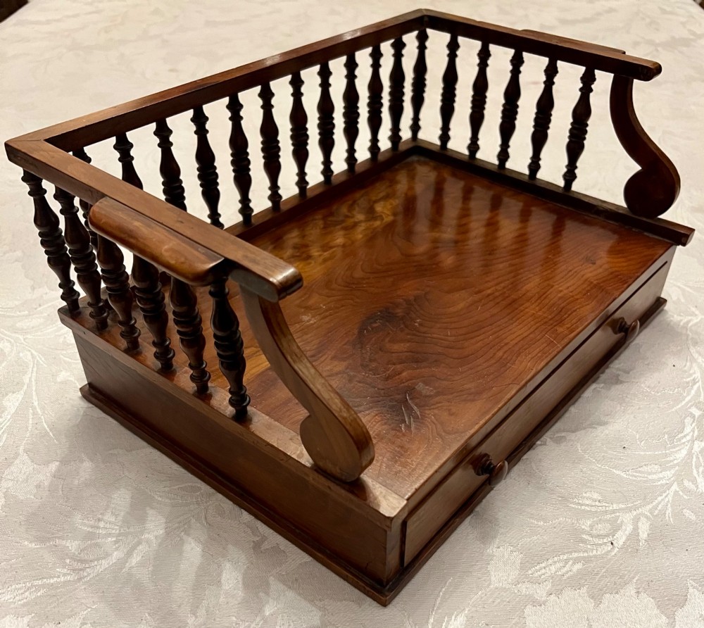 An antique yew wood desktop book trough featuring turned spindle gallery railings on three sides and a smooth timber base. View VIII