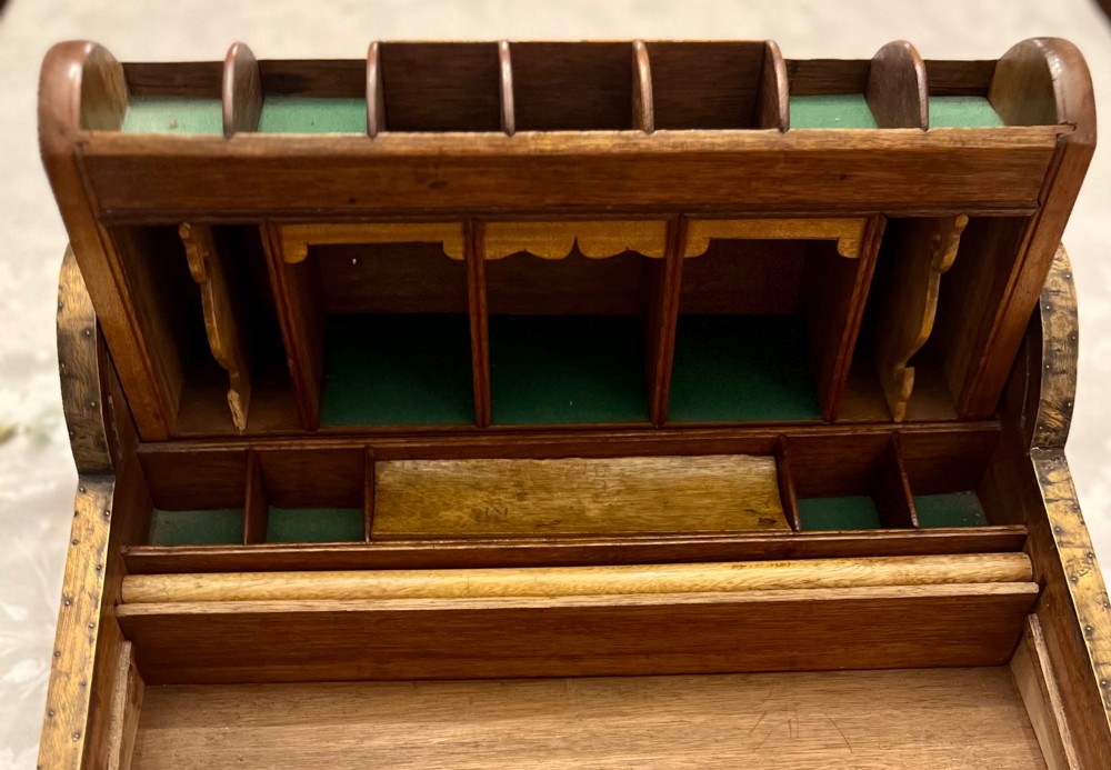 An Anglo Indian camphorwood campaign writing box featuring a ribbed tambour top section, protective brass corner strapping, geometric inlay, and a central brass plaque. View IV