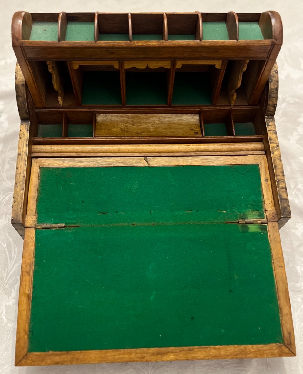 An Anglo Indian camphorwood campaign writing box featuring a ribbed tambour top section, protective brass corner strapping, geometric inlay, and a central brass plaque. View V