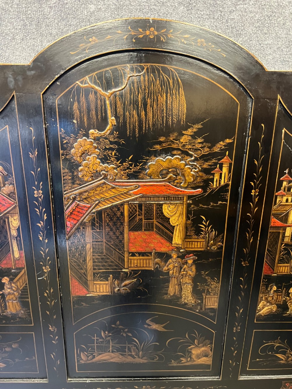 A black lacquered single bedstead featuring hand-painted gold Chinoiserie architectural scenes, arched top panels, and carved cabriole legs. View II