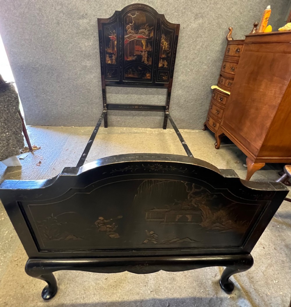 A black lacquered single bedstead featuring hand-painted gold Chinoiserie architectural scenes, arched top panels, and carved cabriole legs. View V