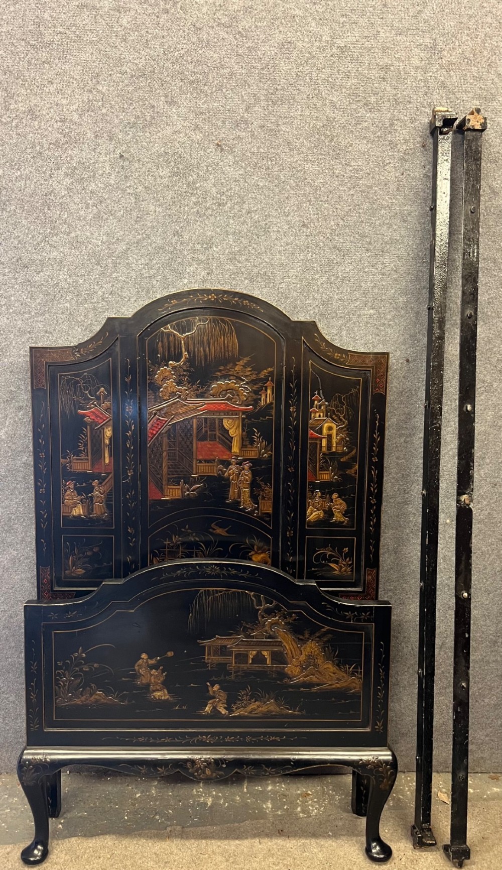 A black lacquered single bedstead featuring hand-painted gold Chinoiserie architectural scenes, arched top panels, and carved cabriole legs. View VI
