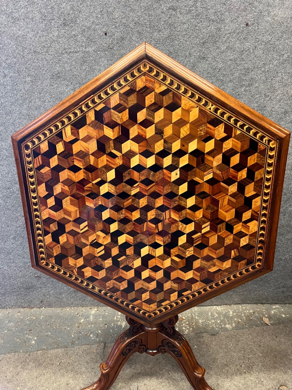 A 19th-century hexagonal specimen wood table featuring a geometric optical illusion parquetry top set on a carved central pedestal base. View III