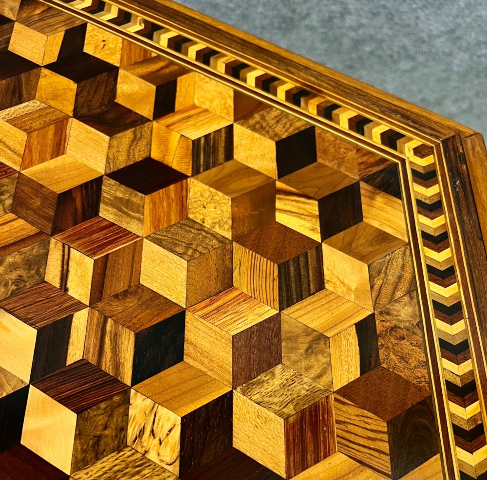 A 19th-century hexagonal specimen wood table featuring a geometric optical illusion parquetry top set on a carved central pedestal base. View XII