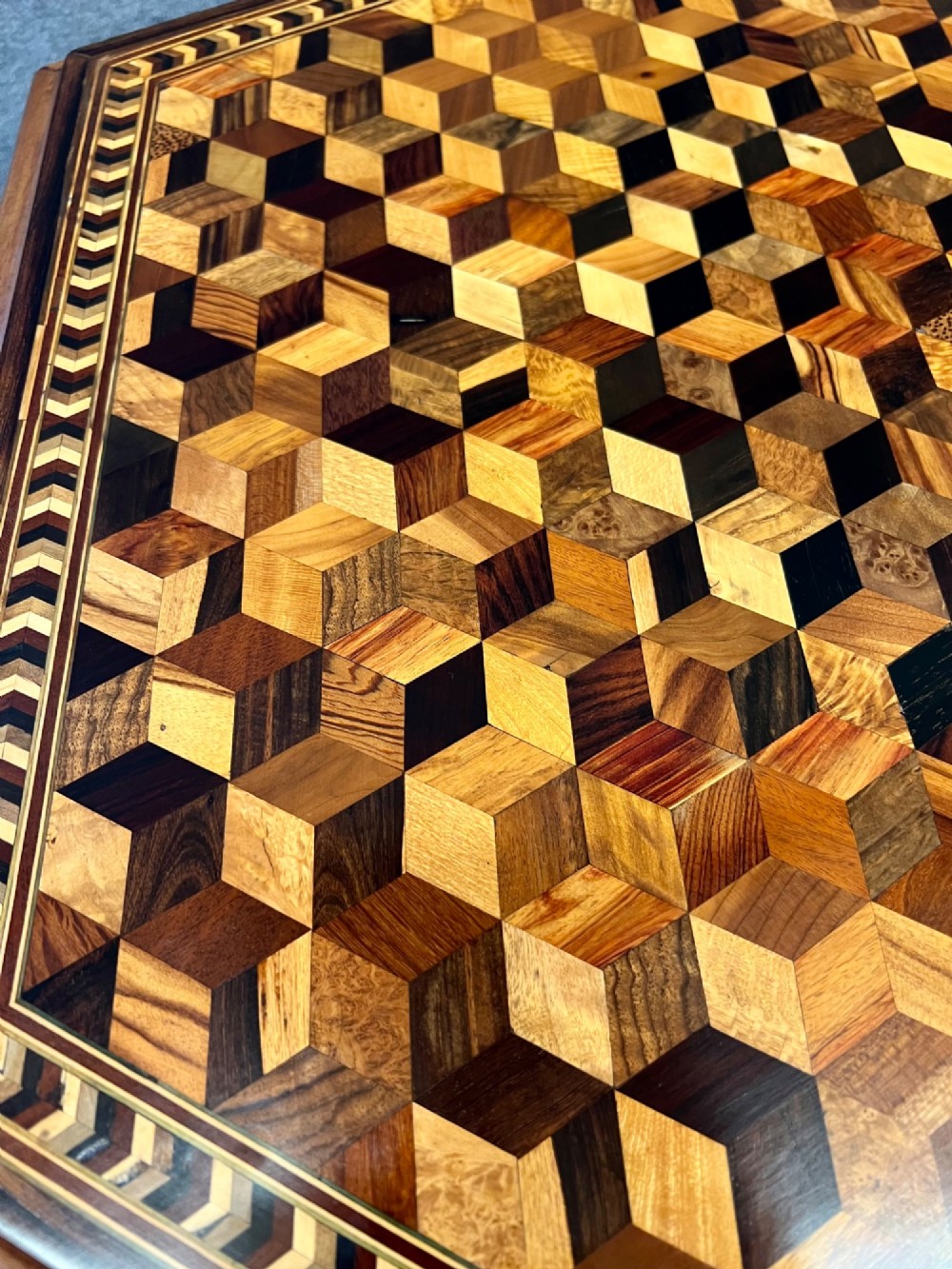 A 19th-century hexagonal specimen wood table featuring a geometric optical illusion parquetry top set on a carved central pedestal base. View XIII