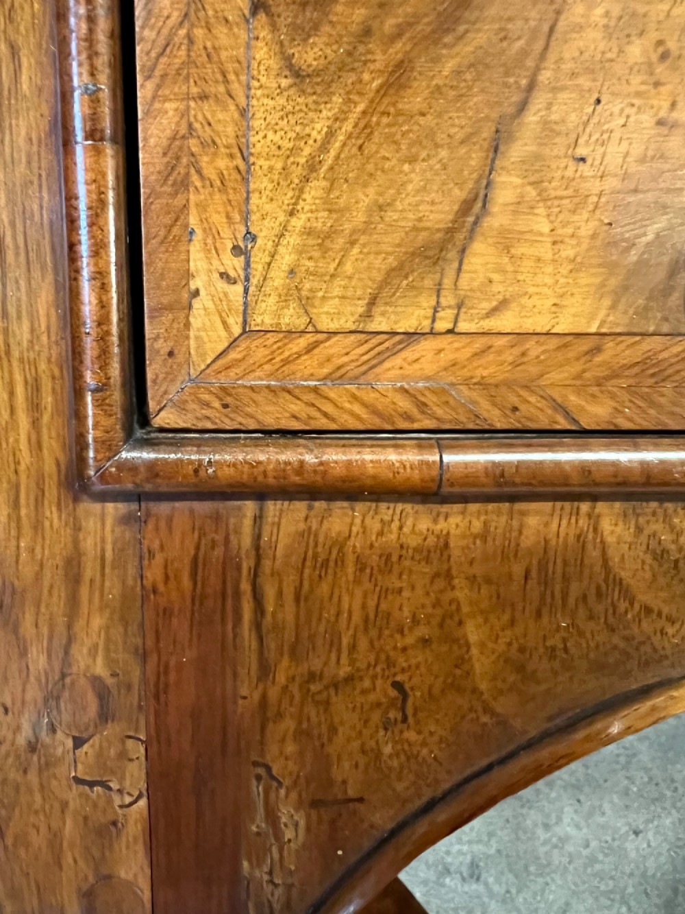 A William and Mary style walnut lowboy table featuring a quartered figured veneer top, a single drawer with brass drop handles, a shaped apron, turned legs, and a serpentine stretcher. View IV