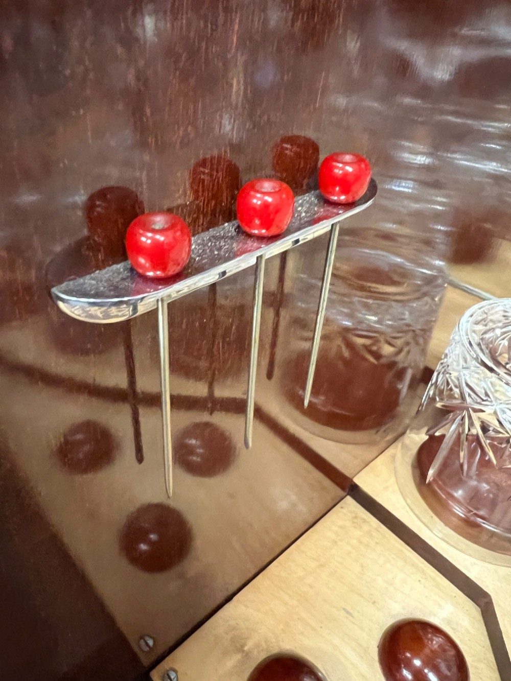 An open Art Deco walnut cocktail cabinet displaying a fitted mirrored interior with glassware, a silver-plated tray, and carved cabriole legs. View X