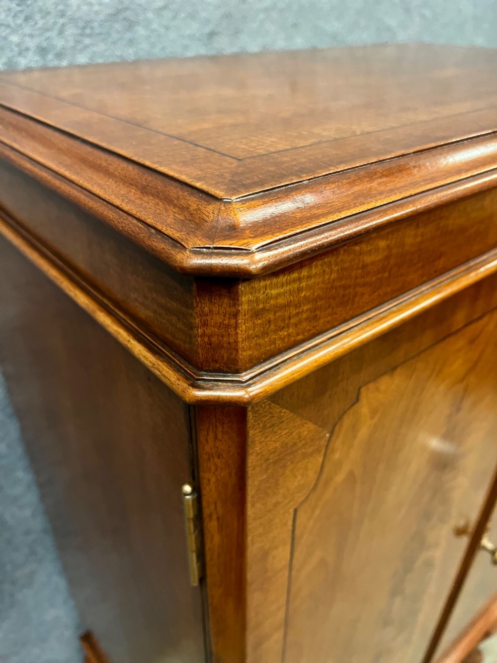 An open Art Deco walnut cocktail cabinet displaying a fitted mirrored interior with glassware, a silver-plated tray, and carved cabriole legs. View XII