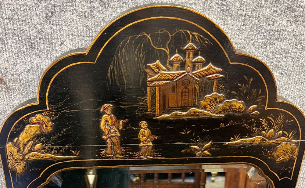 A tall, narrow black lacquered hall mirror decorated with gilded Chinoiserie pagodas and figures, featuring an arched top and front cabriole legs. View II